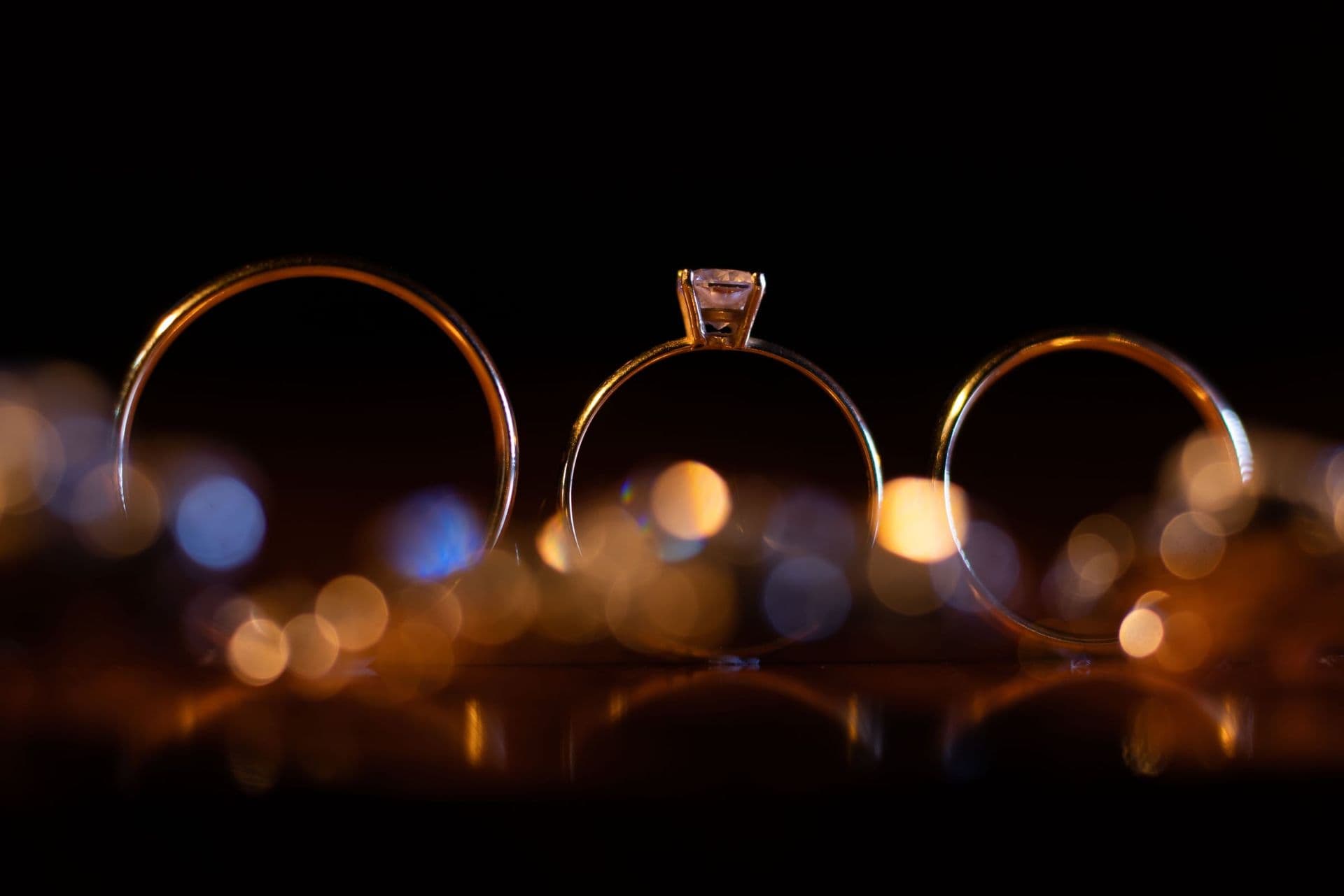 Wedding rings and an engagement ring on a dark background