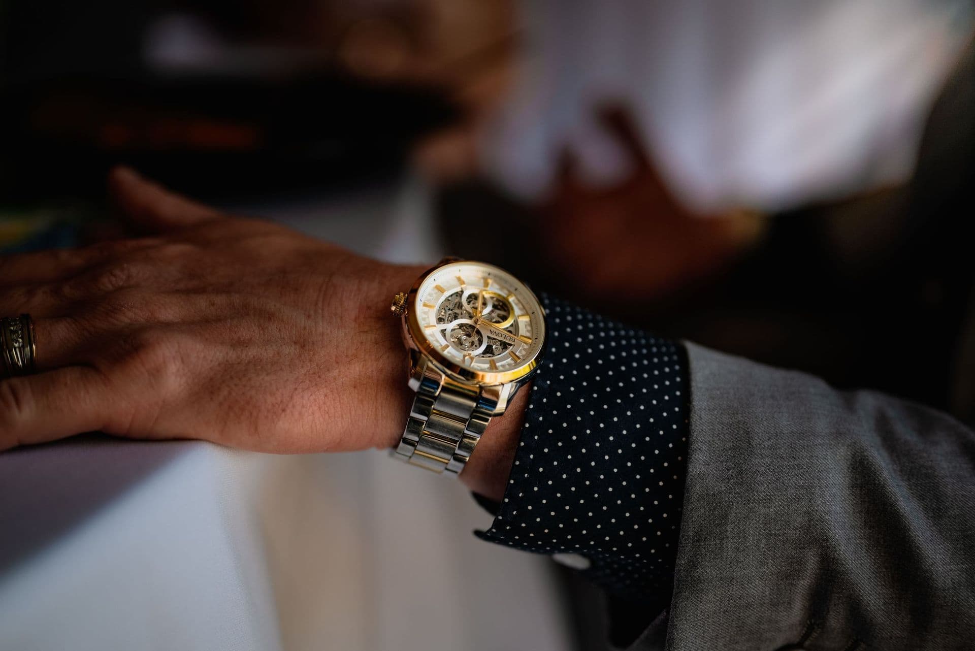 A men's watch with a gold dial on the wrist