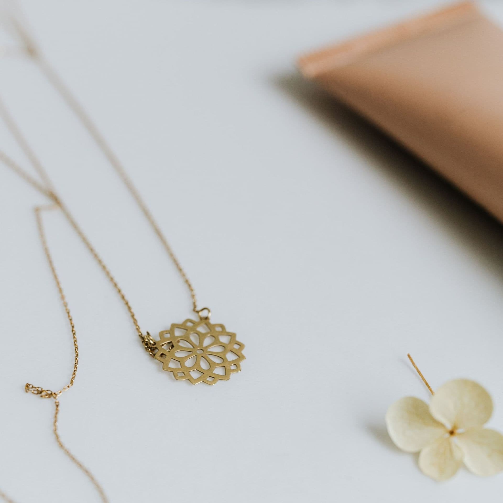 A gold necklace with a filigree flower