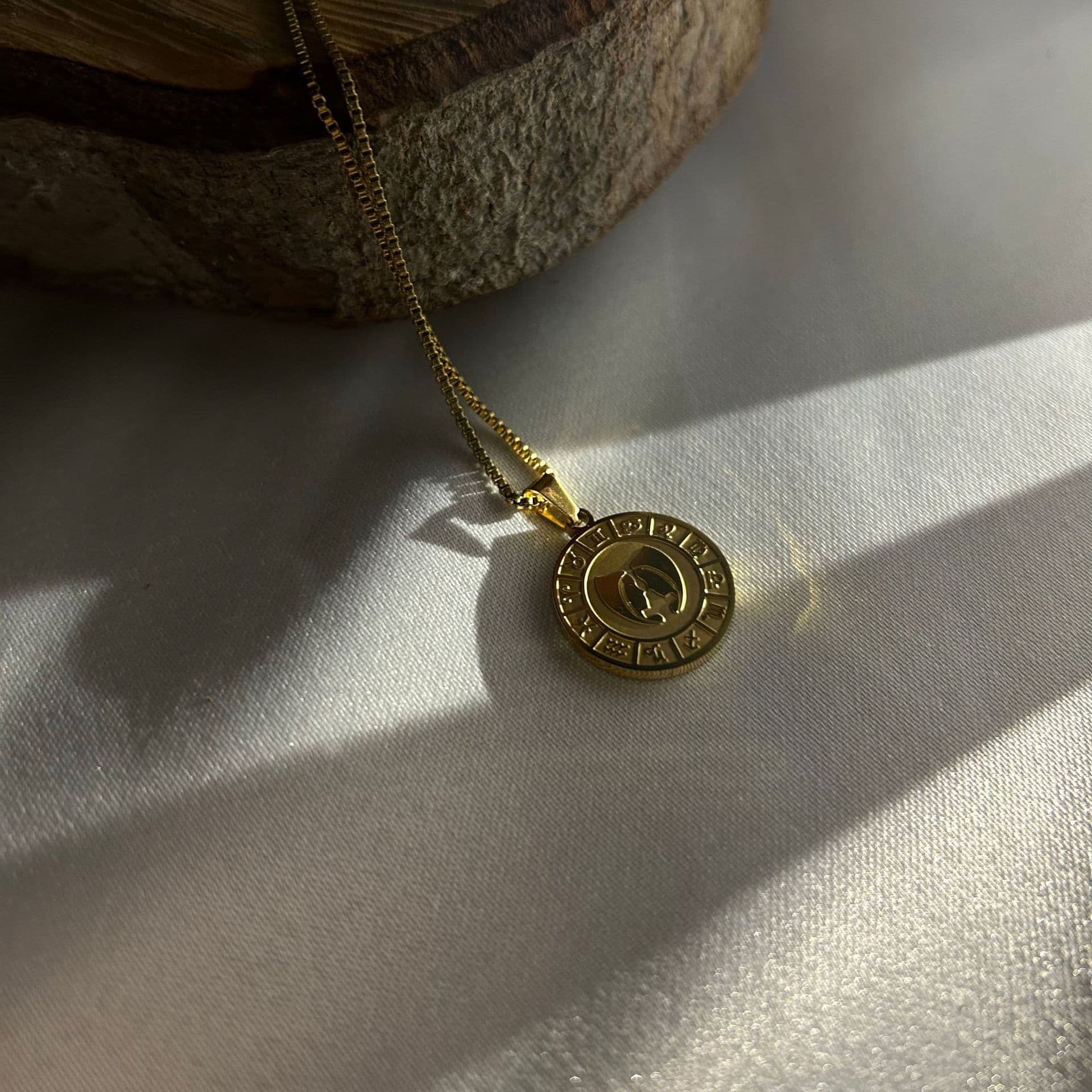 A gold necklace with a medallion