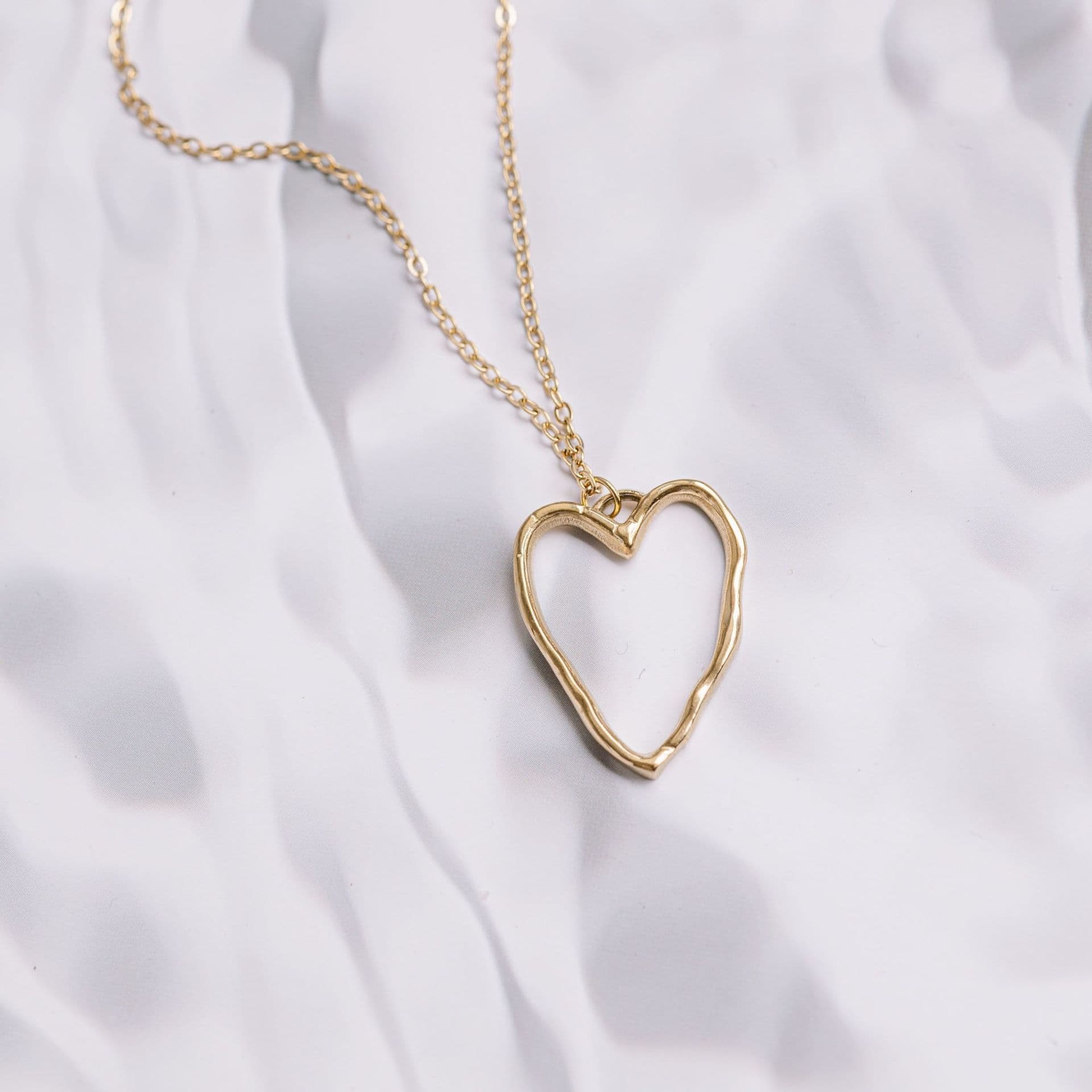 A gold necklace with a heart pendant