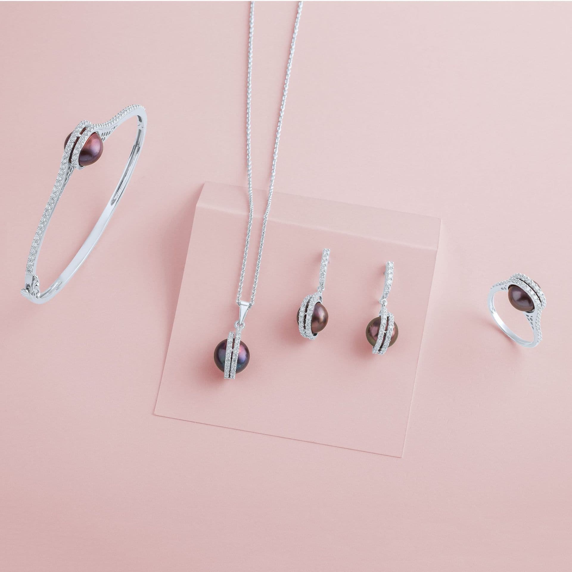 A silver jewellery set with dark pearls